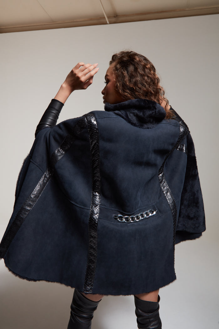 Shearling navy cape with python details and a chrome chain 